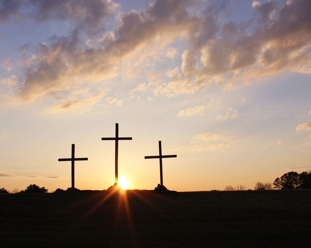 Three Crosses silhouetted against a setting sun